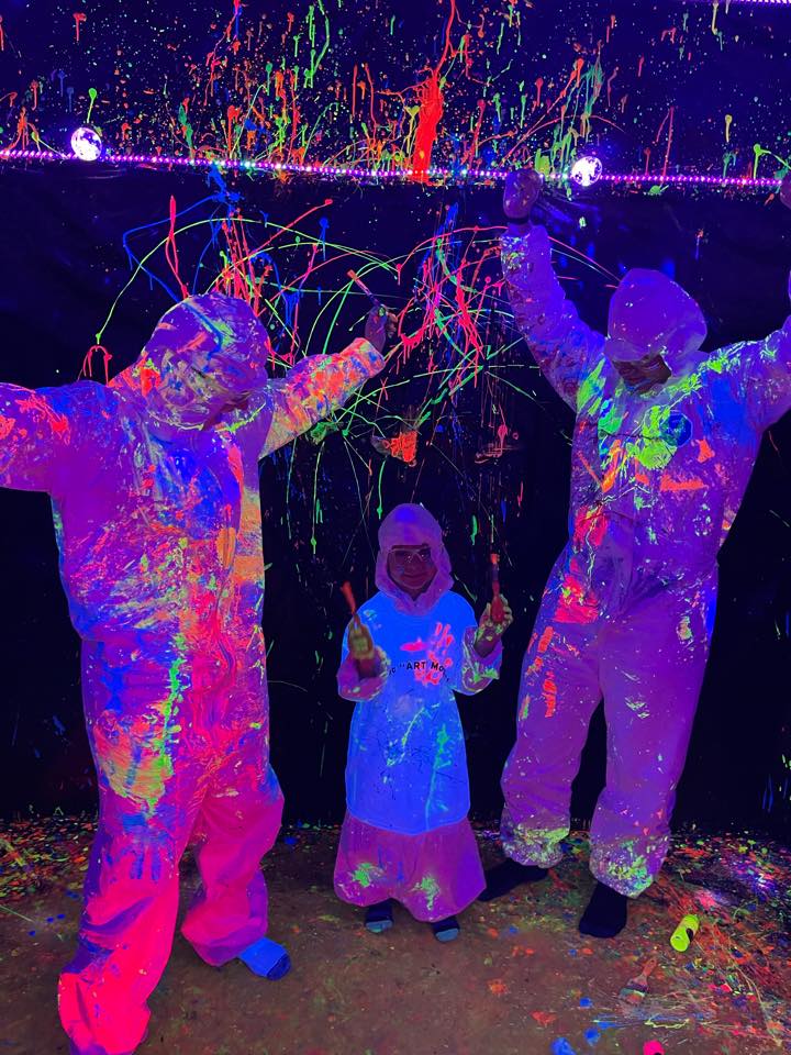 Family covered in glowing paint